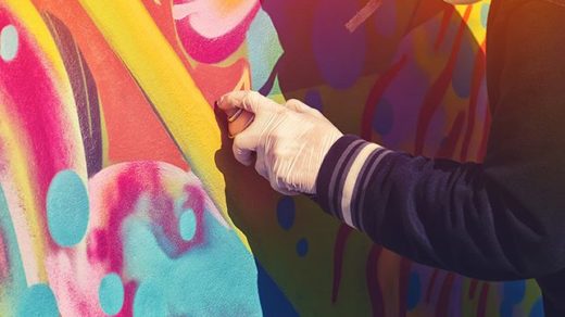 creative street artist spray-painting a mural